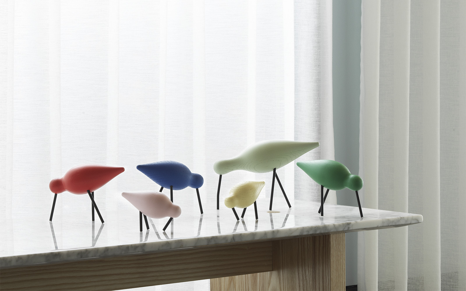 Shorebird - Red, Pink, Blue, Dusty green, Yellow and green - standing on a Solid Table - Normann Copenhagen